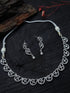 Silver necklace and earrings set on a dark wooden surface